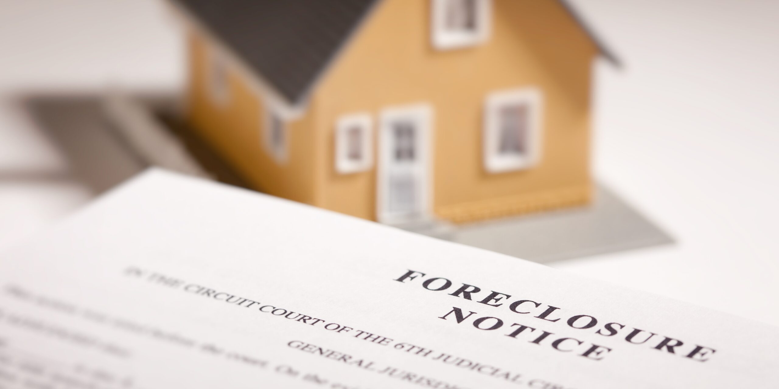 Official foreclosure notice summons document sitting in front of a model home representing a Florida circuit court lawsuit.